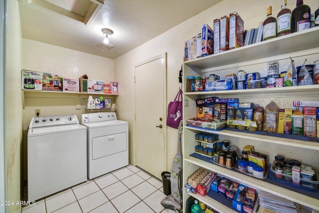 11630 N 74th Dr, Peoria, AZ 85345 - clothes washing area featuring attic access, light tile patterned floors, a textured ceiling, washer and dryer, and laundry area