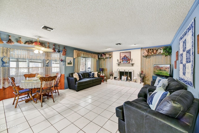 11630 N 74th Dr, Peoria, AZ 85345 - living area featuring light tile patterned floors, a textured ceiling, a lit fireplace, and visible vents
