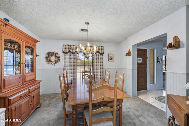 11630 N 74th Dr, Peoria, AZ 85345 - dining area with an inviting chandelier, a textured ceiling, a wainscoted wall, visible vents, and light carpet