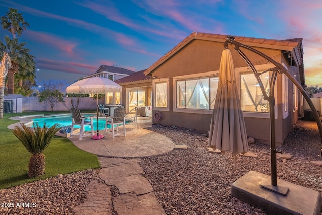 10722 E Keats Ave, Mesa, AZ 85209 - back of property at dusk with a fenced in pool, a patio area, a fenced backyard, and stucco siding