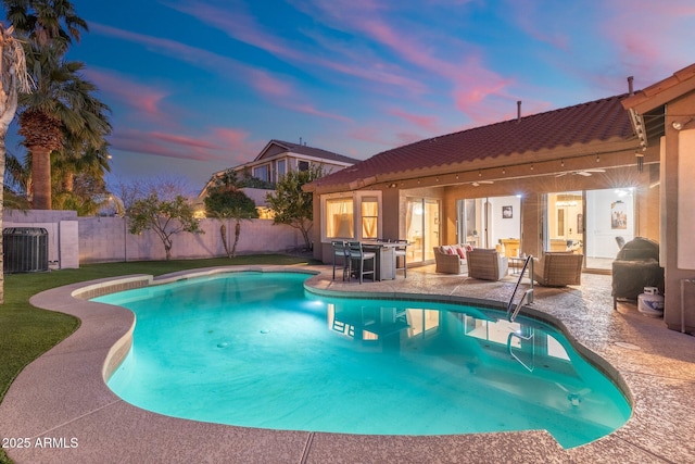 10722 E Keats Ave, Mesa, AZ 85209 - pool at dusk featuring central AC unit, a fenced backyard, a patio, an outdoor hangout area, and a fenced in pool