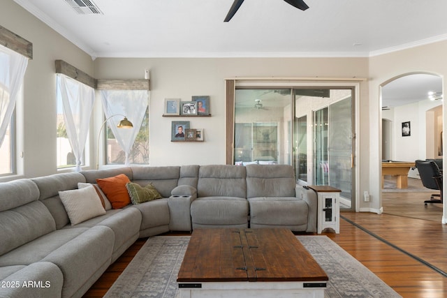 10722 E Keats Ave, Mesa, AZ 85209 - living room featuring crown molding, ceiling fan, arched walkways, visible vents, and wood finished floors