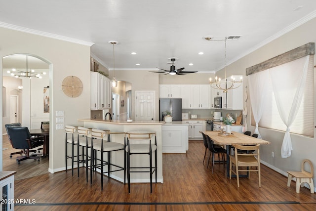 10722 E Keats Ave, Mesa, AZ 85209 - kitchen featuring dark wood finished floors, arched walkways, a peninsula, a breakfast bar, and stainless steel refrigerator with ice dispenser