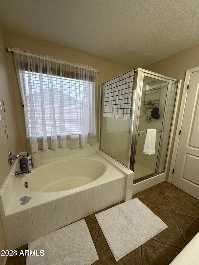 bathroom with shower with separate bathtub, tile patterned flooring, and a textured ceiling