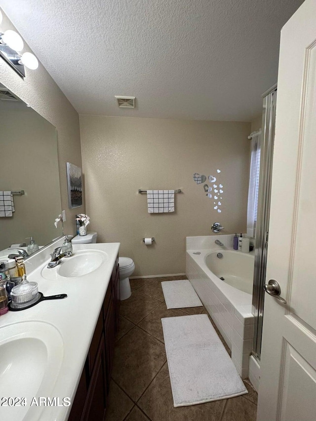 full bathroom with tile patterned flooring, vanity, a textured ceiling, and toilet