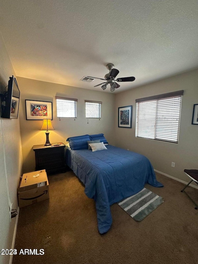 bedroom featuring ceiling fan, carpet floors, and a textured ceiling