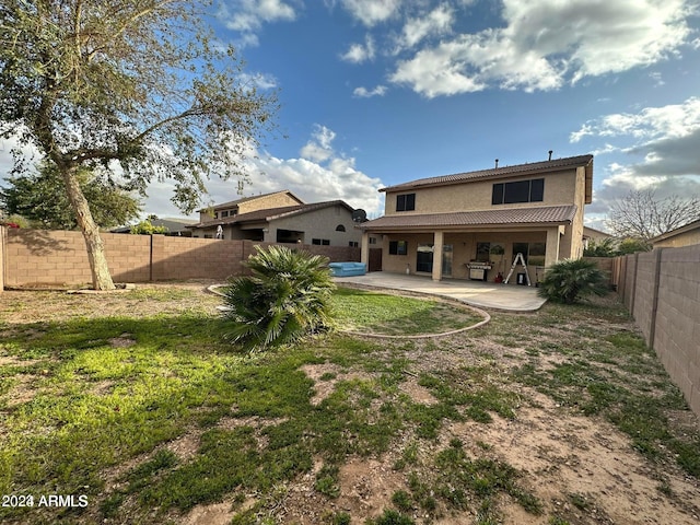 back of property featuring a yard and a patio area