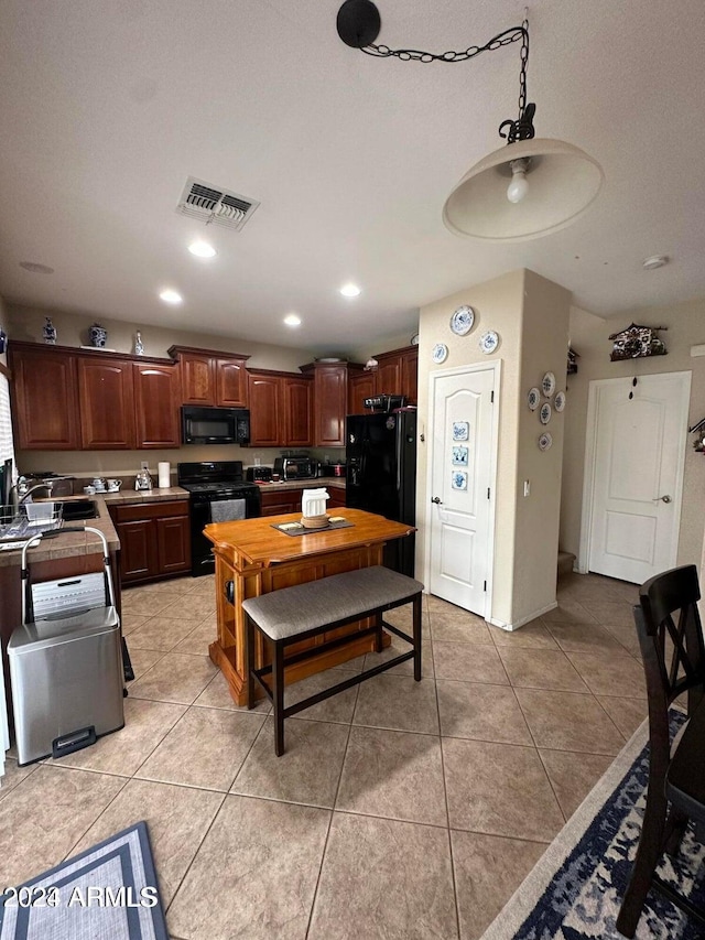 kitchen featuring sink, black appliances, and light tile patterned flooring