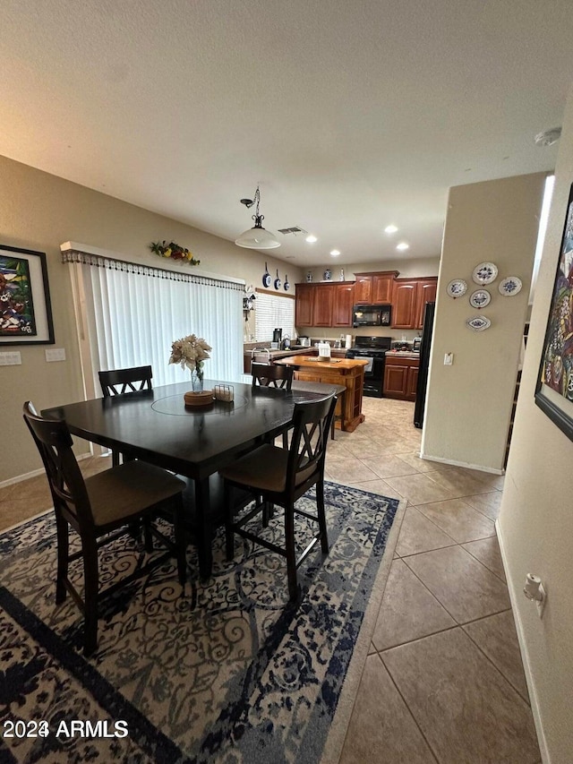 tiled dining room with a textured ceiling