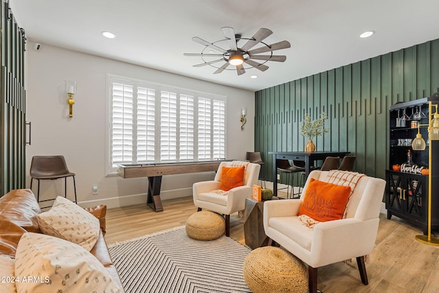 living area featuring light hardwood / wood-style floors and ceiling fan