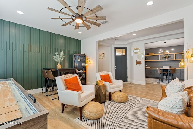 sitting room featuring light hardwood / wood-style floors and ceiling fan with notable chandelier