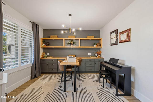 dining area with light hardwood / wood-style flooring and an inviting chandelier