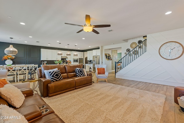 living room featuring light hardwood / wood-style floors and ceiling fan