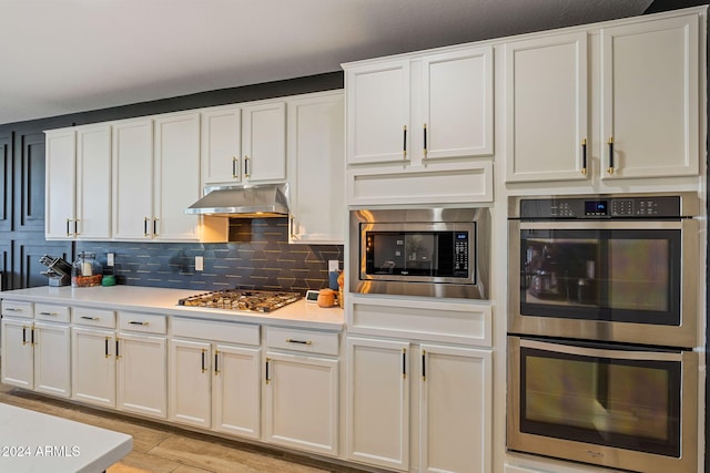 kitchen with appliances with stainless steel finishes, decorative backsplash, and white cabinets