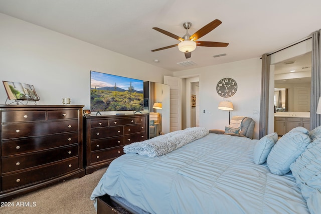 bedroom featuring ceiling fan, ensuite bath, and light colored carpet