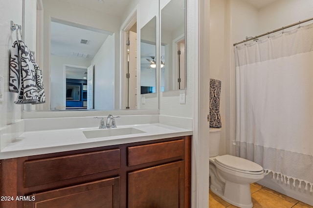 full bathroom featuring ceiling fan, toilet, shower / bath combo with shower curtain, vanity, and tile patterned flooring