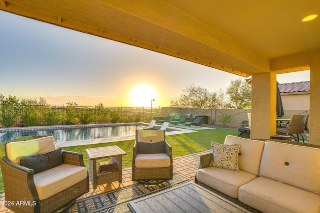 patio terrace at dusk featuring a water view, an outdoor living space, a lawn, and a fenced in pool