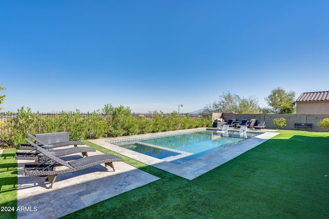 view of swimming pool featuring a patio and a yard