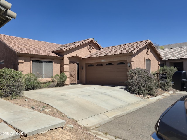 2125 E Danbury Rd, Phoenix, AZ 85022 - view of front of house featuring stucco siding, a garage, a tiled roof, and driveway