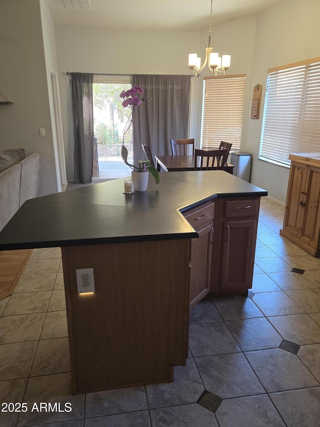 2125 E Danbury Rd, Phoenix, AZ 85022 - kitchen with a chandelier, a center island, hanging light fixtures, dark countertops, and tile patterned floors