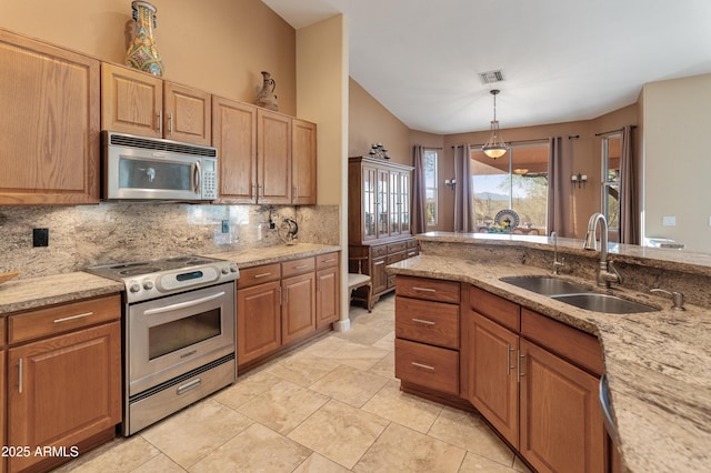 43638 N 22nd St, New River, AZ 85087 - kitchen with appliances with stainless steel finishes, a sink, tasteful backsplash, light stone countertops, and hanging light fixtures