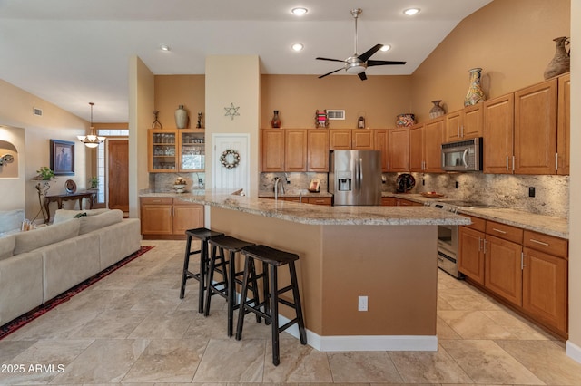 43638 N 22nd St, New River, AZ 85087 - kitchen featuring appliances with stainless steel finishes, vaulted ceiling, a breakfast bar, backsplash, and ceiling fan
