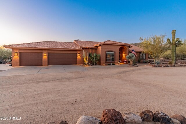 43638 N 22nd St, New River, AZ 85087 - mediterranean / spanish house featuring a garage, driveway, a tile roof, and stucco siding