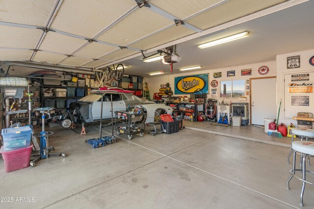 43638 N 22nd St, New River, AZ 85087 - garage featuring a garage door opener and a workshop area
