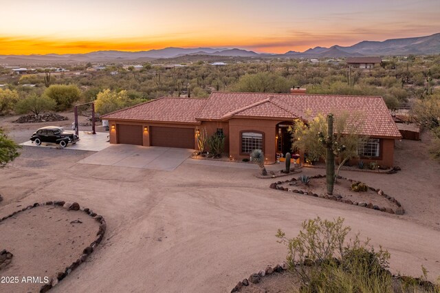 43638 N 22nd St, New River, AZ 85087 - mediterranean / spanish home with a tile roof, a mountain view, concrete driveway, a chimney, and an attached garage