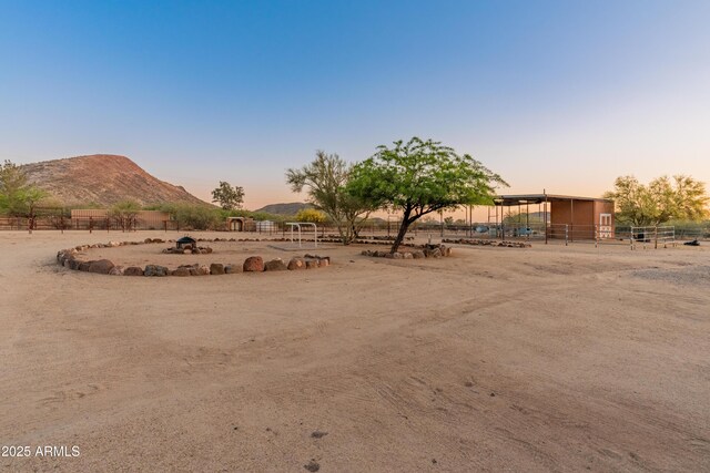 43638 N 22nd St, New River, AZ 85087 - yard at dusk featuring an exterior structure, an outbuilding, a view of countryside, and a mountain view
