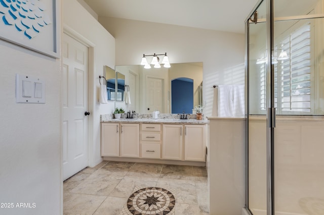 bathroom with lofted ceiling, vanity, and walk in shower