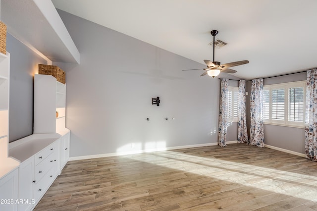 unfurnished living room with hardwood / wood-style floors, vaulted ceiling, and ceiling fan