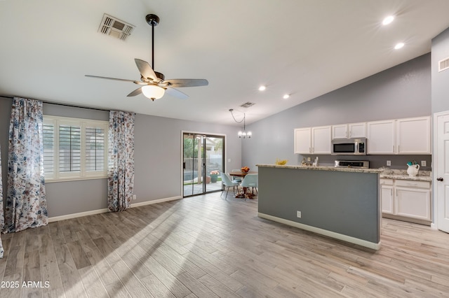 kitchen featuring ceiling fan with notable chandelier, decorative light fixtures, white cabinetry, light stone counters, and light hardwood / wood-style flooring