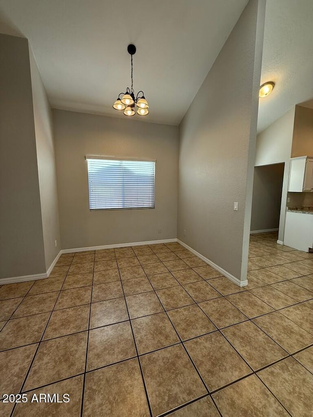 unfurnished room featuring tile patterned flooring, a notable chandelier, and baseboards