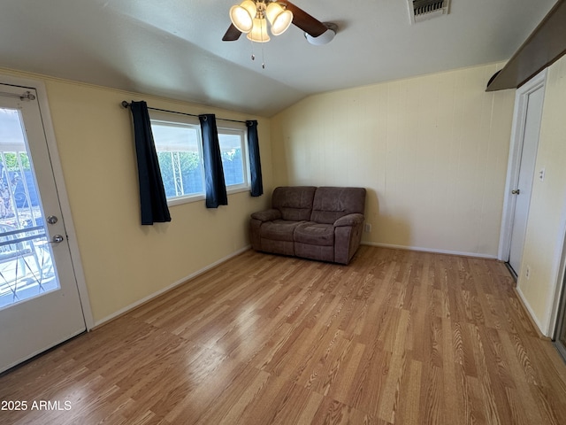 unfurnished room featuring light wood finished floors, lofted ceiling, visible vents, a ceiling fan, and baseboards