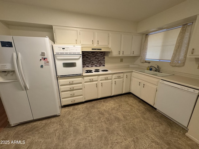 kitchen with white appliances, white cabinets, light countertops, under cabinet range hood, and a sink