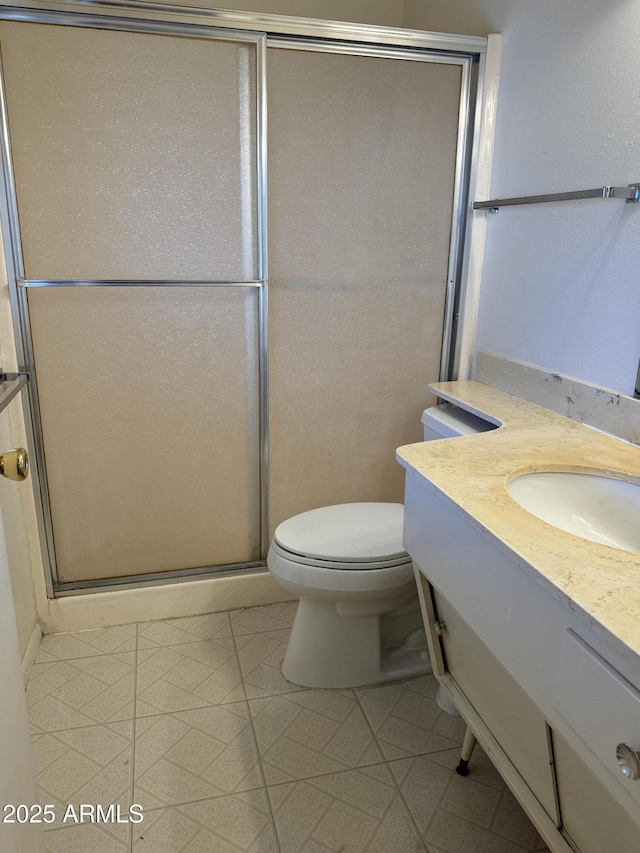 full bath featuring toilet, a stall shower, and vanity