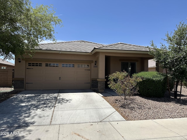 24645 W Atlanta Ave, Buckeye, AZ 85326 - view of front of home featuring concrete driveway, stucco siding, an attached garage, a tiled roof, and stone siding