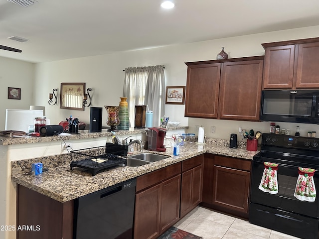 24645 W Atlanta Ave, Buckeye, AZ 85326 - kitchen with black appliances, a peninsula, light tile patterned floors, light stone counters, and dark brown cabinetry