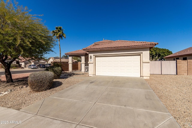 view of front of property with driveway, a tile roof, a gate, fence, and stucco siding