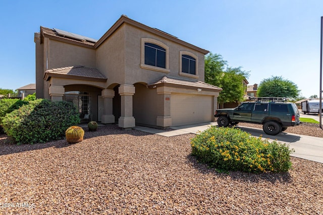 view of front facade featuring a garage and solar panels