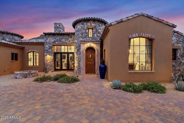 9514 E Madera Dr, Scottsdale, AZ 85262 - mediterranean / spanish-style house featuring stucco siding, a chimney, a fire pit, stone siding, and french doors