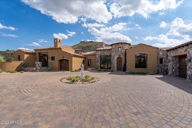 9514 E Madera Dr, Scottsdale, AZ 85262 - mediterranean / spanish house featuring curved driveway, stucco siding, a tile roof, and a chimney