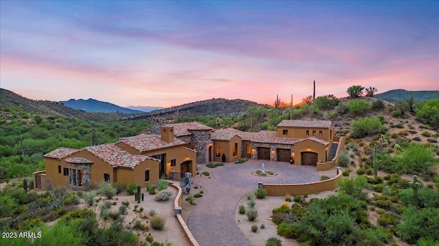 9514 E Madera Dr, Scottsdale, AZ 85262 - view of front of house featuring stucco siding, a mountain view, an attached garage, and curved driveway