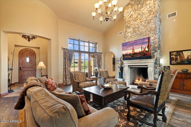9514 E Madera Dr, Scottsdale, AZ 85262 - living room with a fireplace, arched walkways, visible vents, a chandelier, and wood finished floors