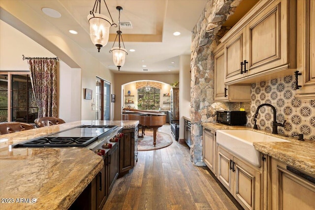 9514 E Madera Dr, Scottsdale, AZ 85262 - kitchen featuring light stone counters, dark wood-type flooring, decorative backsplash, arched walkways, and a sink