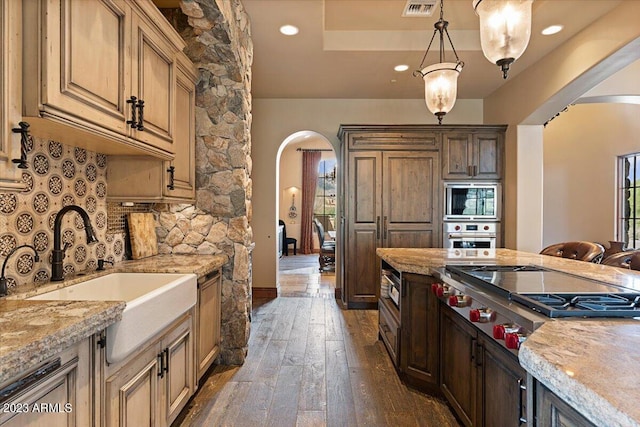 9514 E Madera Dr, Scottsdale, AZ 85262 - kitchen with arched walkways, appliances with stainless steel finishes, dark wood-style flooring, and a sink