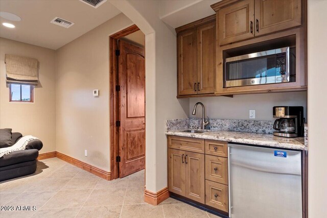 9514 E Madera Dr, Scottsdale, AZ 85262 - kitchen with baseboards, light stone counters, visible vents, stainless steel appliances, and a sink