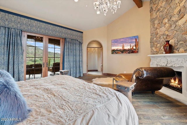 9514 E Madera Dr, Scottsdale, AZ 85262 - bedroom with a large fireplace, baseboards, lofted ceiling with beams, arched walkways, and wood finished floors