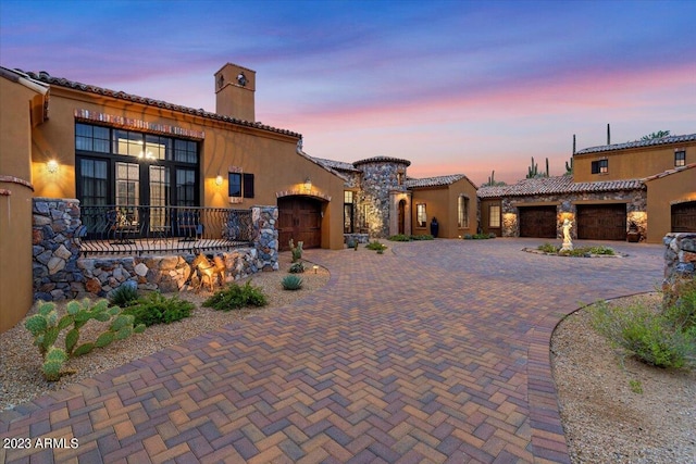 9514 E Madera Dr, Scottsdale, AZ 85262 - mediterranean / spanish-style home with a garage, decorative driveway, stucco siding, and a chimney